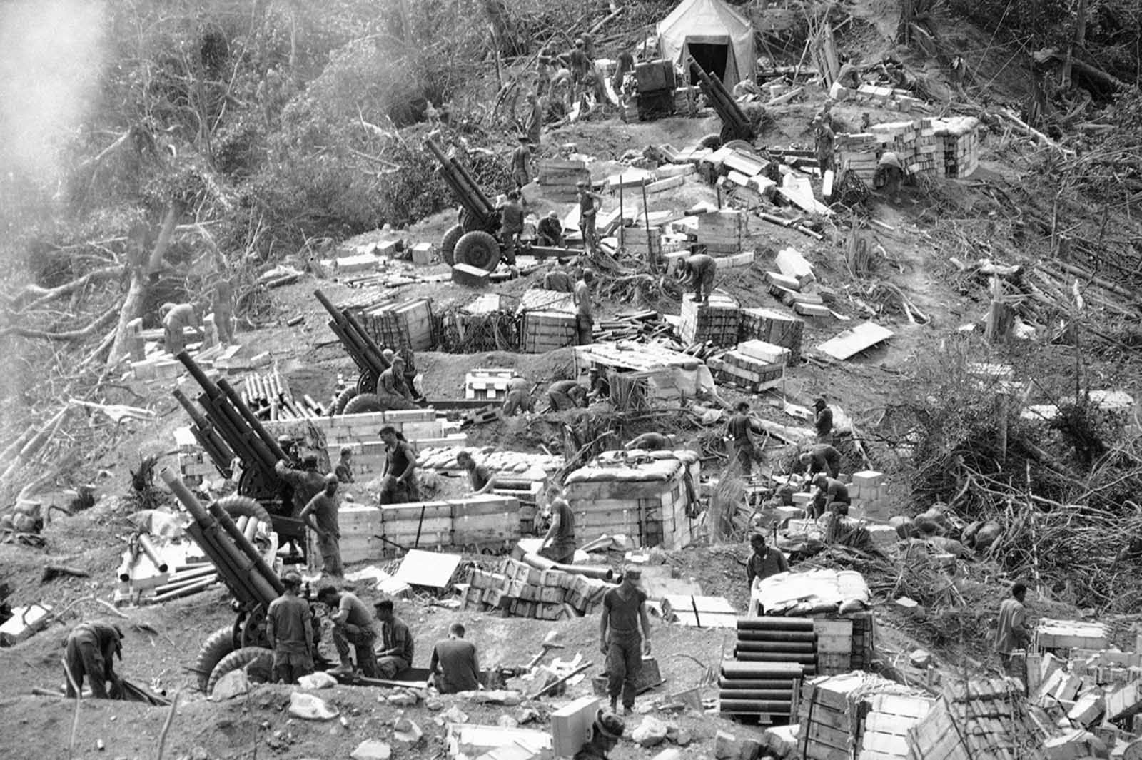 Marines prepare their 105-mm Howitzers for action at the end of a day in which this dense jungle area west of Hue was chopped down and molded into a fire-support base for a sweep of the area on February 18, 1969. Troops used explosives and earth-moving equipment to carve out the gun pits and bunkers which by nightfall became a fire-support base.