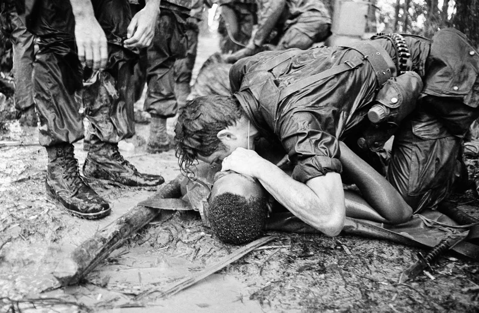 A trooper of the 101st Airborne Division attempts to save the life of a buddy at Dong Ap Bia Mountain, near South Vietnam's A Shau Valley on May 19, 1969. The man was seriously wounded in the last of repeated attempts by U.S. forces to capture enemy positions there.