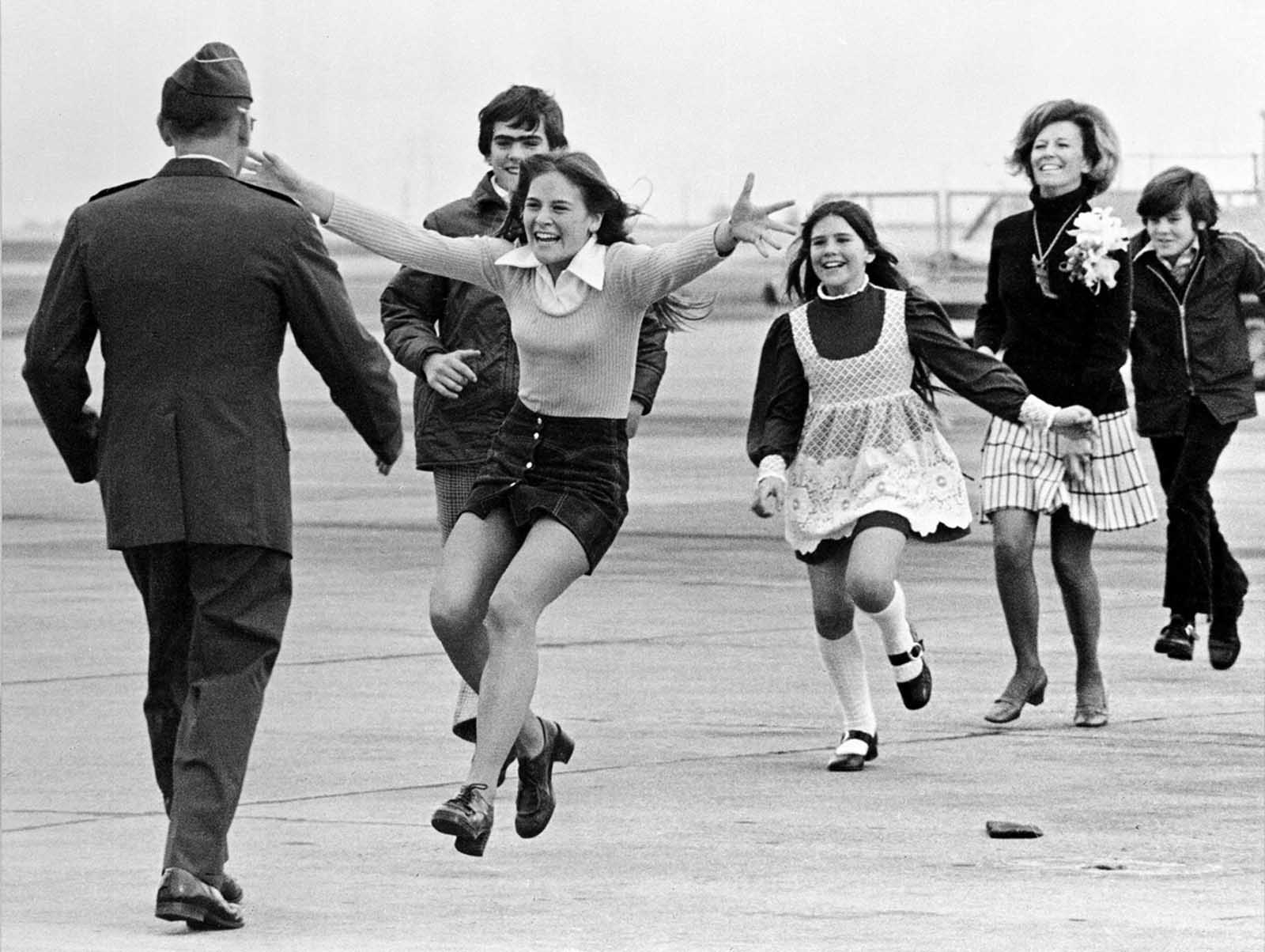 The released prisoner of war Lieutenant Colonel Robert L. Stirm is greeted by his family at Travis Air Force Base in Fairfield, California, as he returns home from the Vietnam War, March 17, 1973. In the lead is Stirm's daughter Lori, 15; followed by son Robert, 14; daughter Cynthia, 11; wife Loretta and son Roger, 12. This famous photo, also called