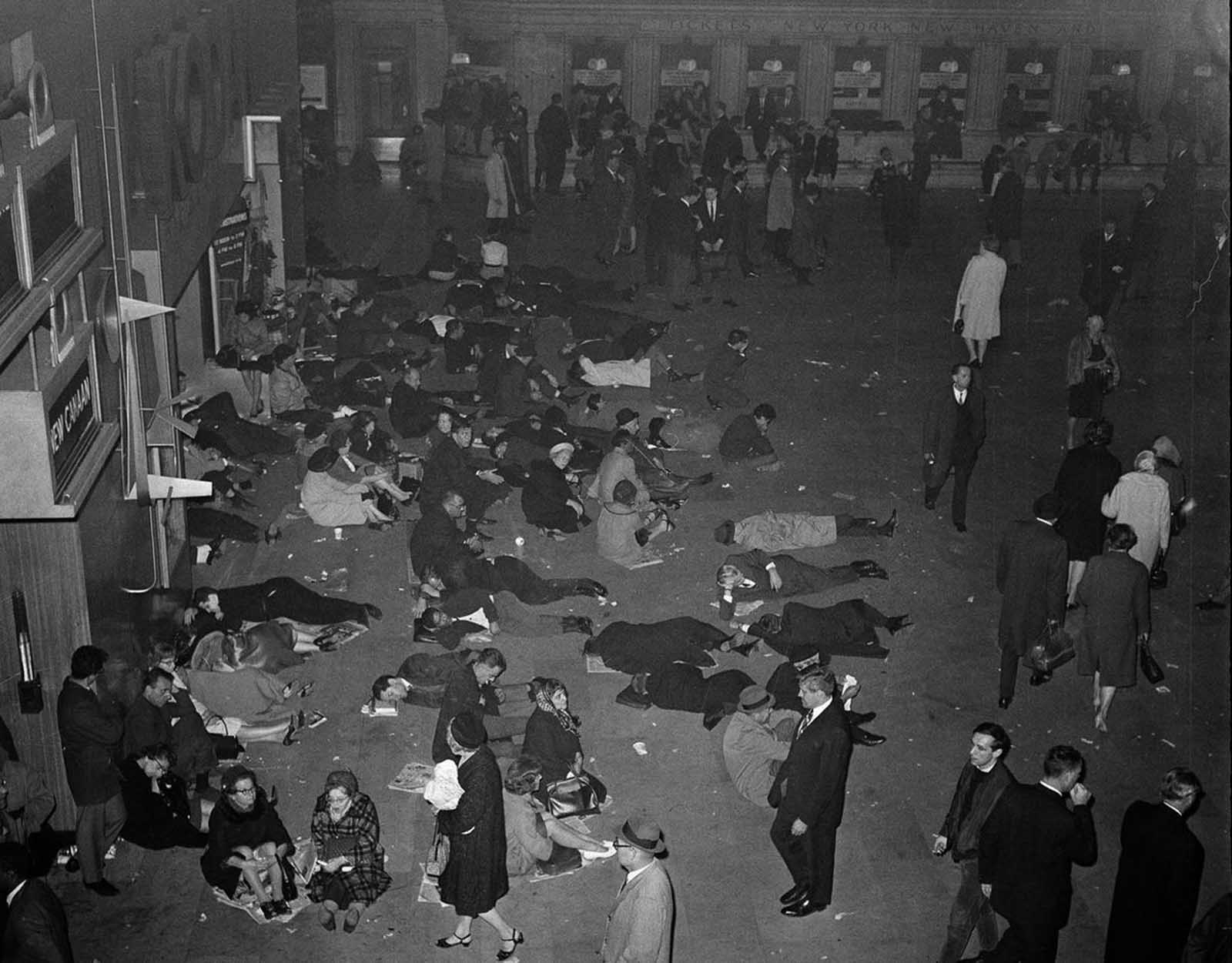 People sleep sitting and lying down at Grand Central Terminal's main waiting room in New York, during a massive power failure, on November 9, 1965. The area is lit with emergency lighting. The blackout affected New York State, most of New England, parts of New Jersey, Pennsylvania, and Ontario, Canada. 