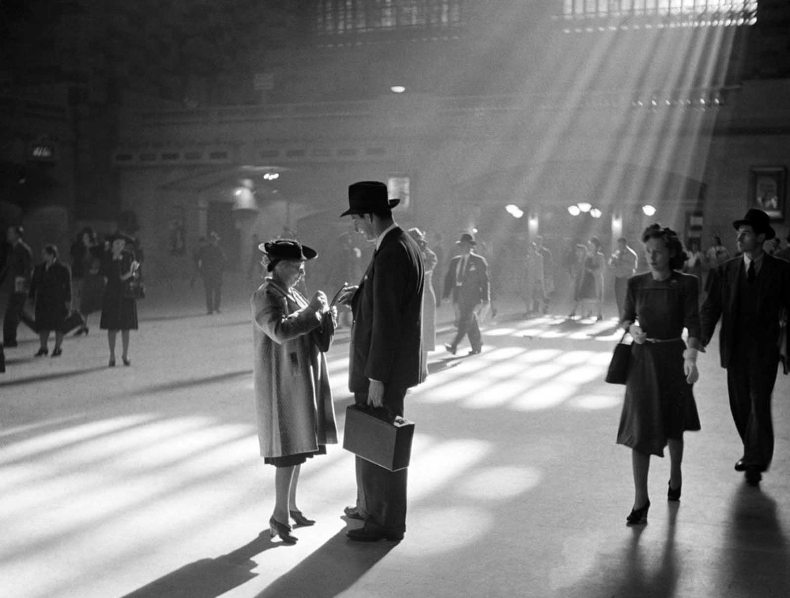 A man and woman talk together as people pass through the Main Concourse of New York's Grand Central Terminal in Midtown Manhattan, in October of 1941.