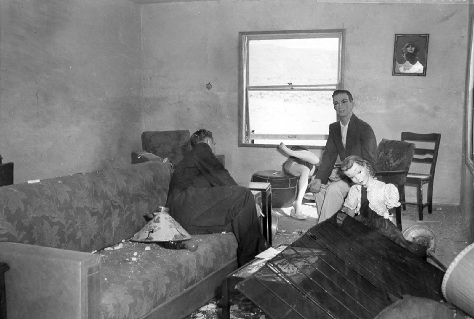 (2 of 2) After the blast, a damaged living room, members of the mannequin family tossed about or missing after an atomic blast on March 17, 1953.