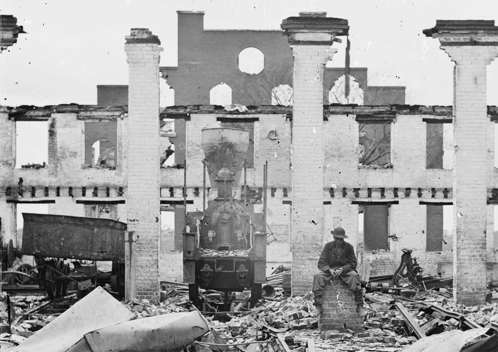 A damaged locomotive among the ruins of the Richmond & Petersburg Railroad depot, in Richmond, Virginia, in April of 1865.
