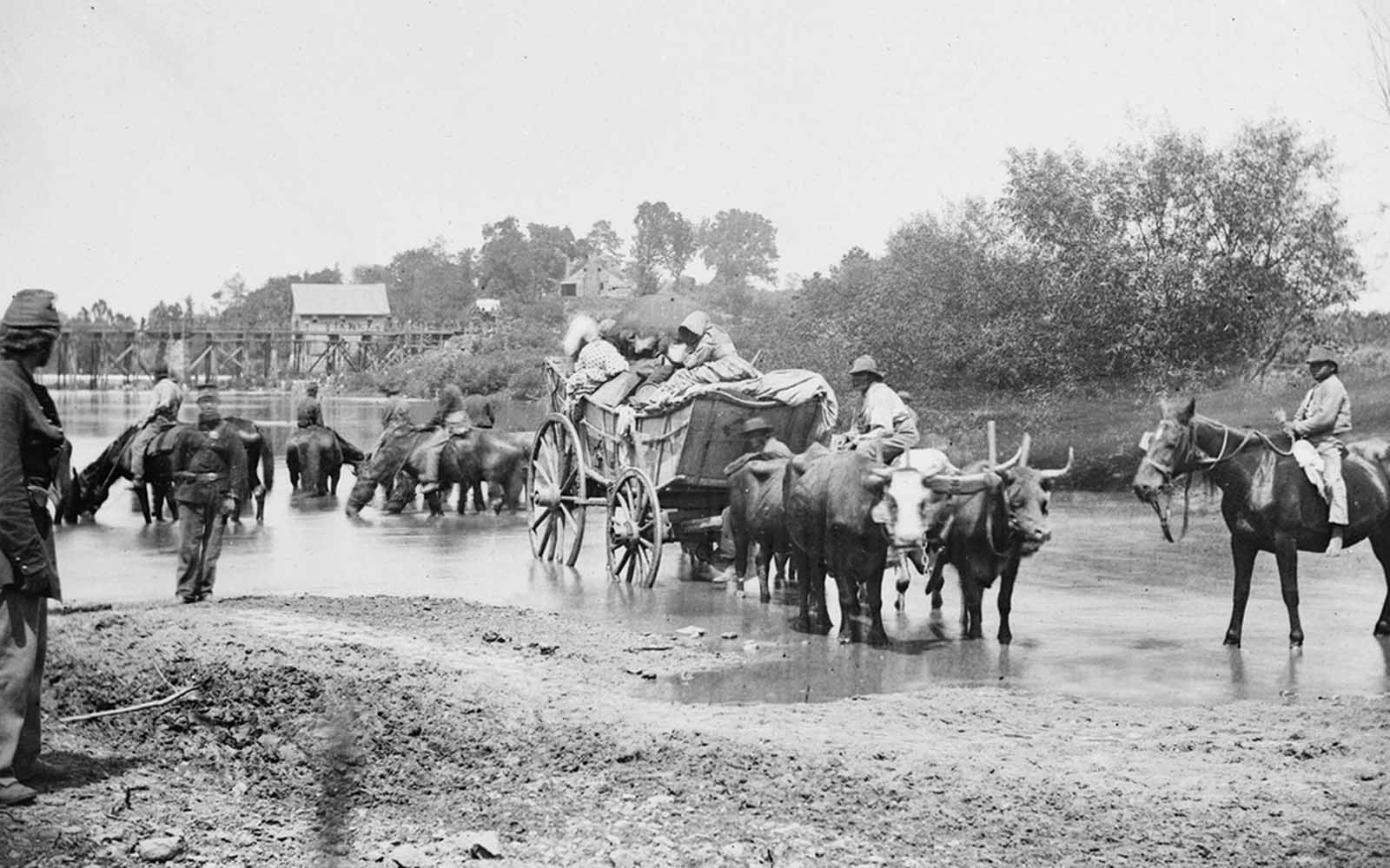 Fugitive African Americans are fording the Rappahannock River in Virginia, August 1862, during the Second Battle of Bull Run.