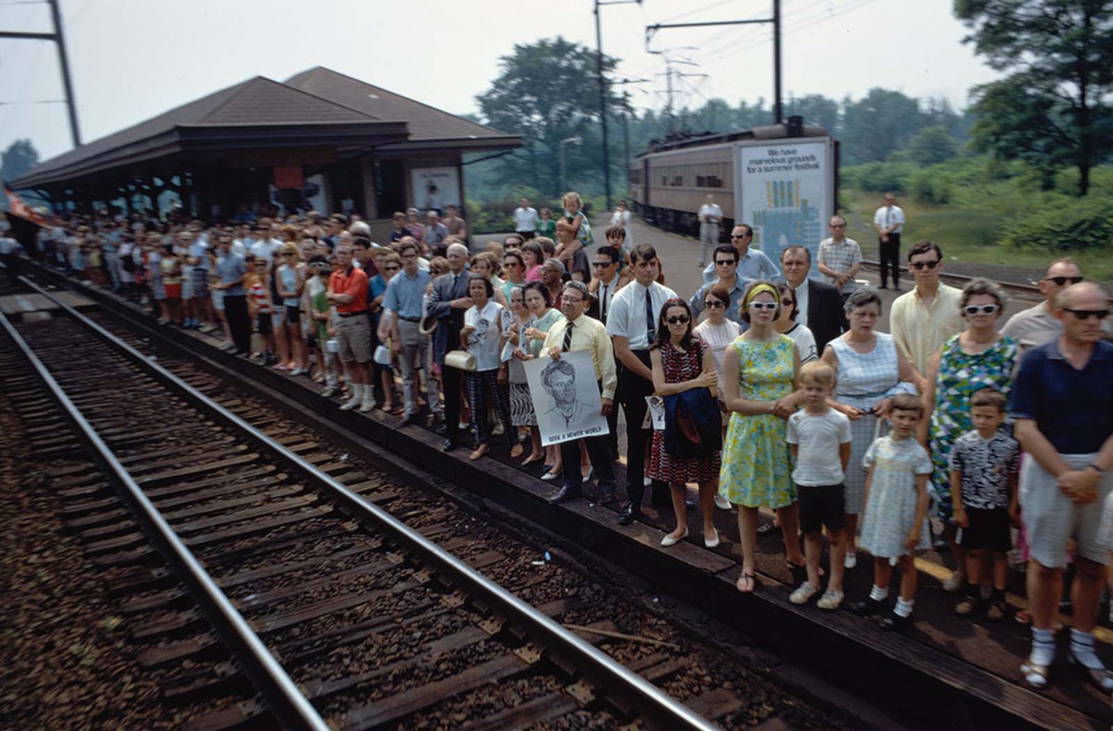 The funeral train rolls through Princeton Junction, New Jersey, on June 8, 1968. Several people hold portraits of Robert F. Kennedy, including a man whose poster reads