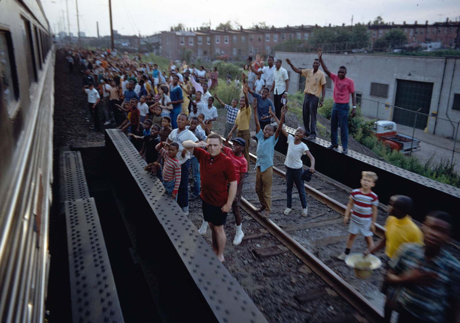 People wave and salute as Robert F. Kennedy's funeral train travels past, rolling from New York City to Washington, D.C., on June 8, 1968.