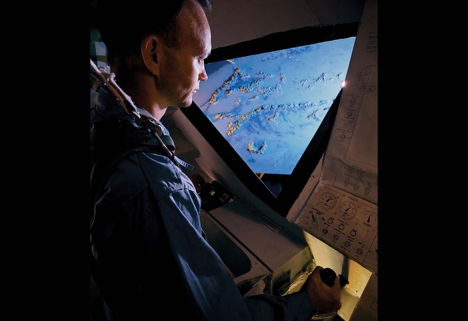 An Apollo astronaut operates a flight simulator during mission training for NASA's space program in Dallas, Texas.