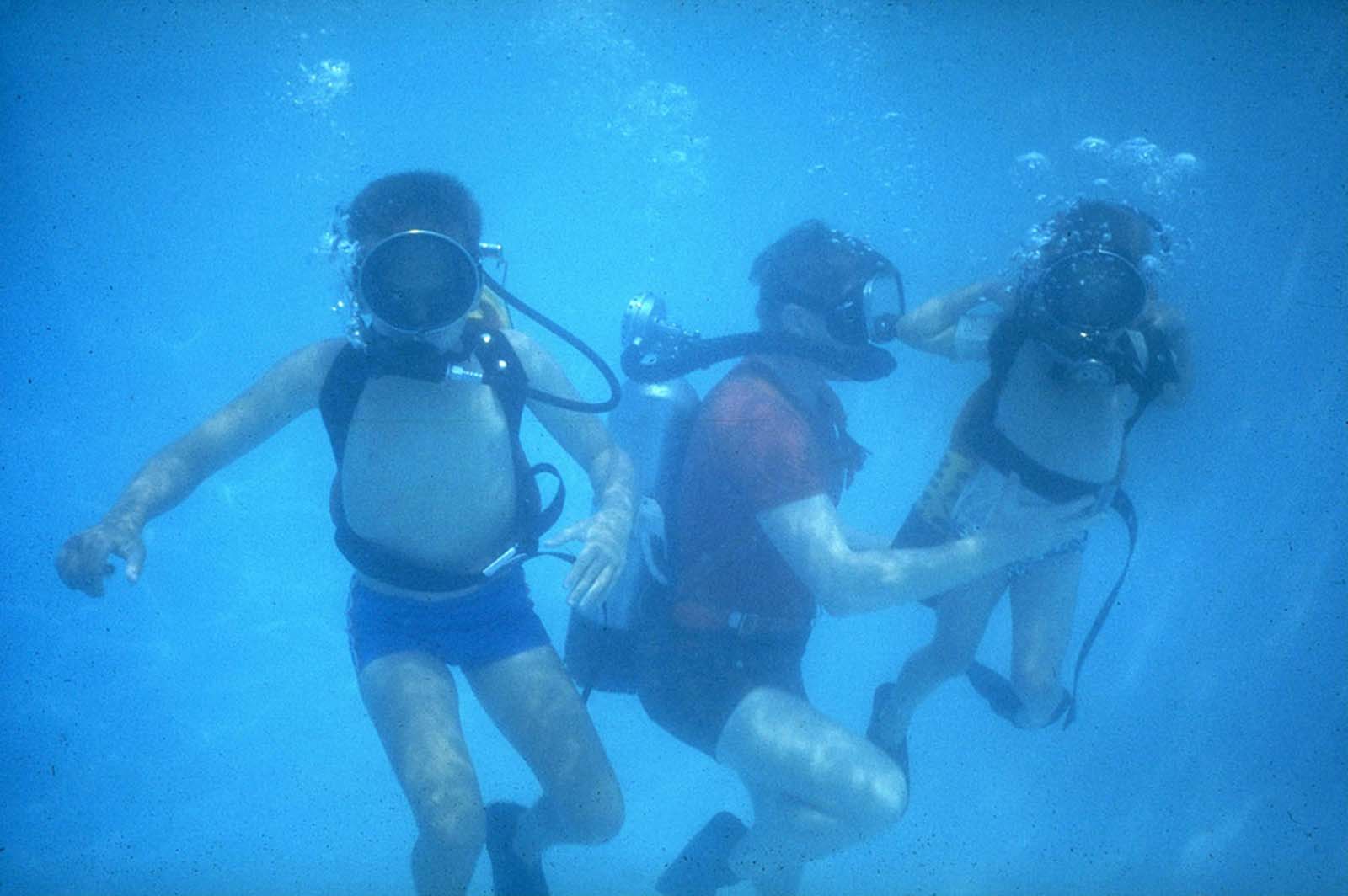 Neil Armstrong and his sons, Ricky and Mark, scuba dive in a swimming pool in Houston, Texas, in March 1969.