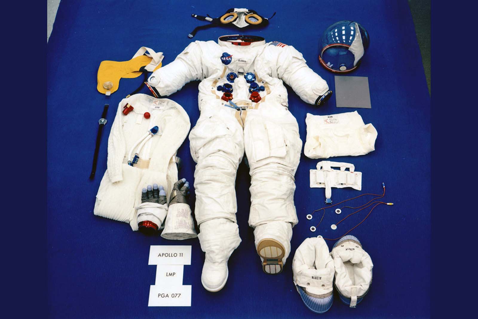 A preflight photo shows Buzz Aldrin's suit laid out in its lunar-surface configuration.