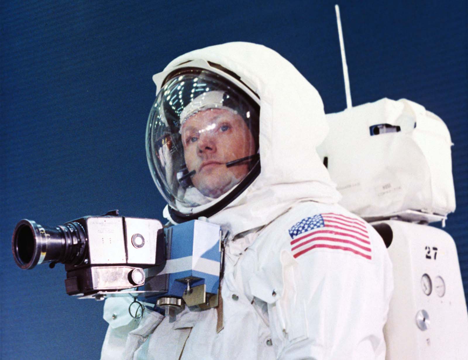 Apollo 11 Commander Neil Armstrong trains in the spacesuit he will wear on the lunar surface. A camera is attached to his chest, giving him full use of his arms; the backpack provides oxygen, pressurization, and temperature control.
