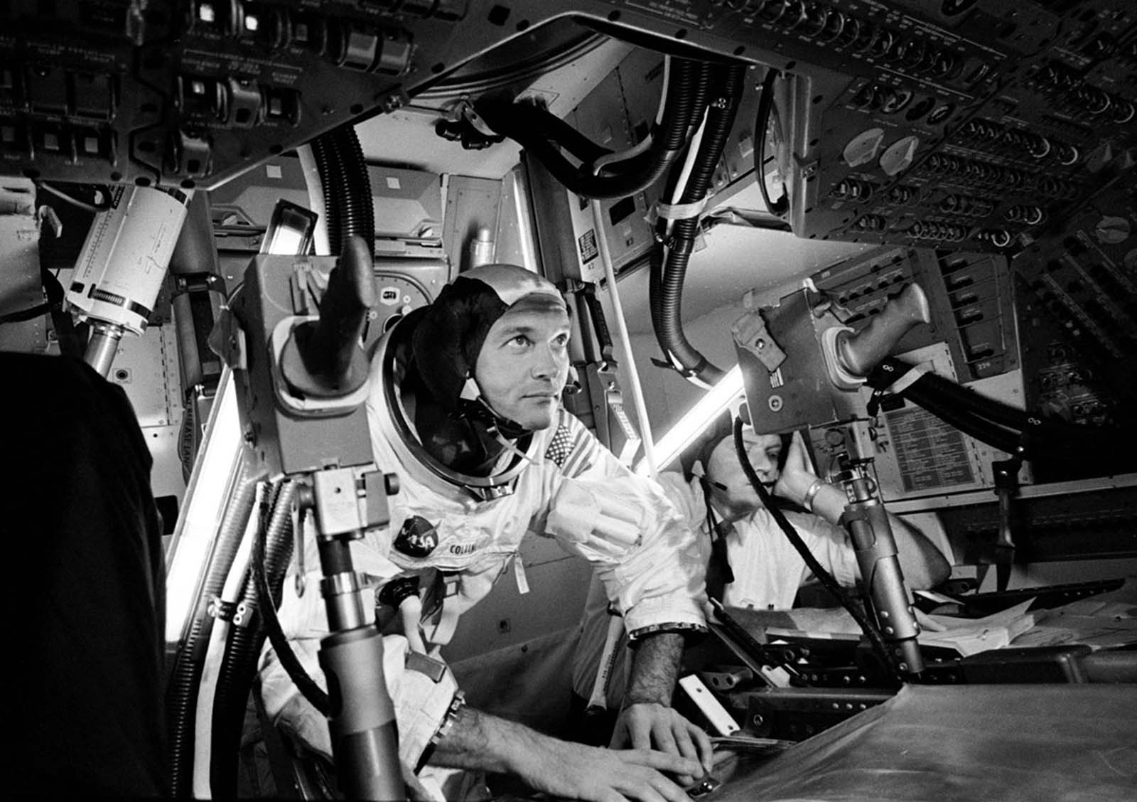 Command Module Pilot Michael Collins works inside a simulator.