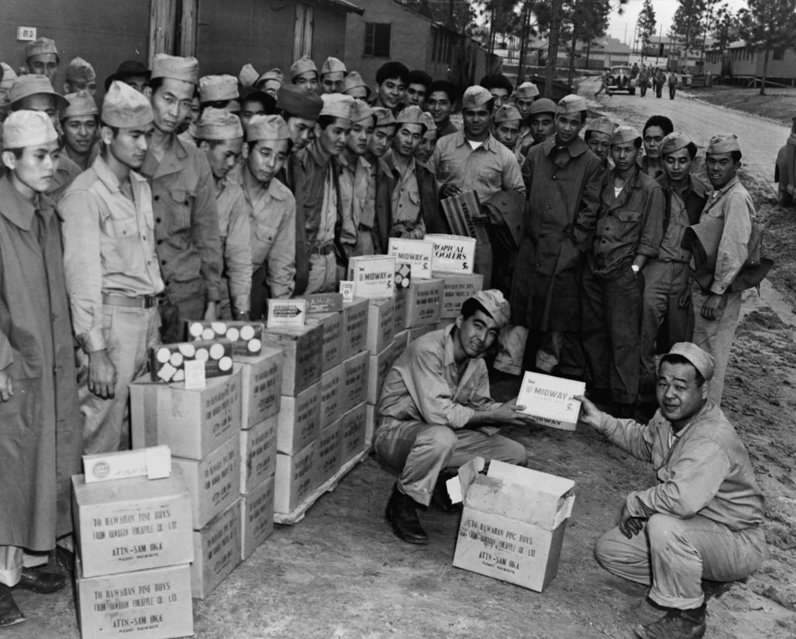 Soldiers distribute candies and cigarettes donated by a Hawaiian pineapple company. 1943.