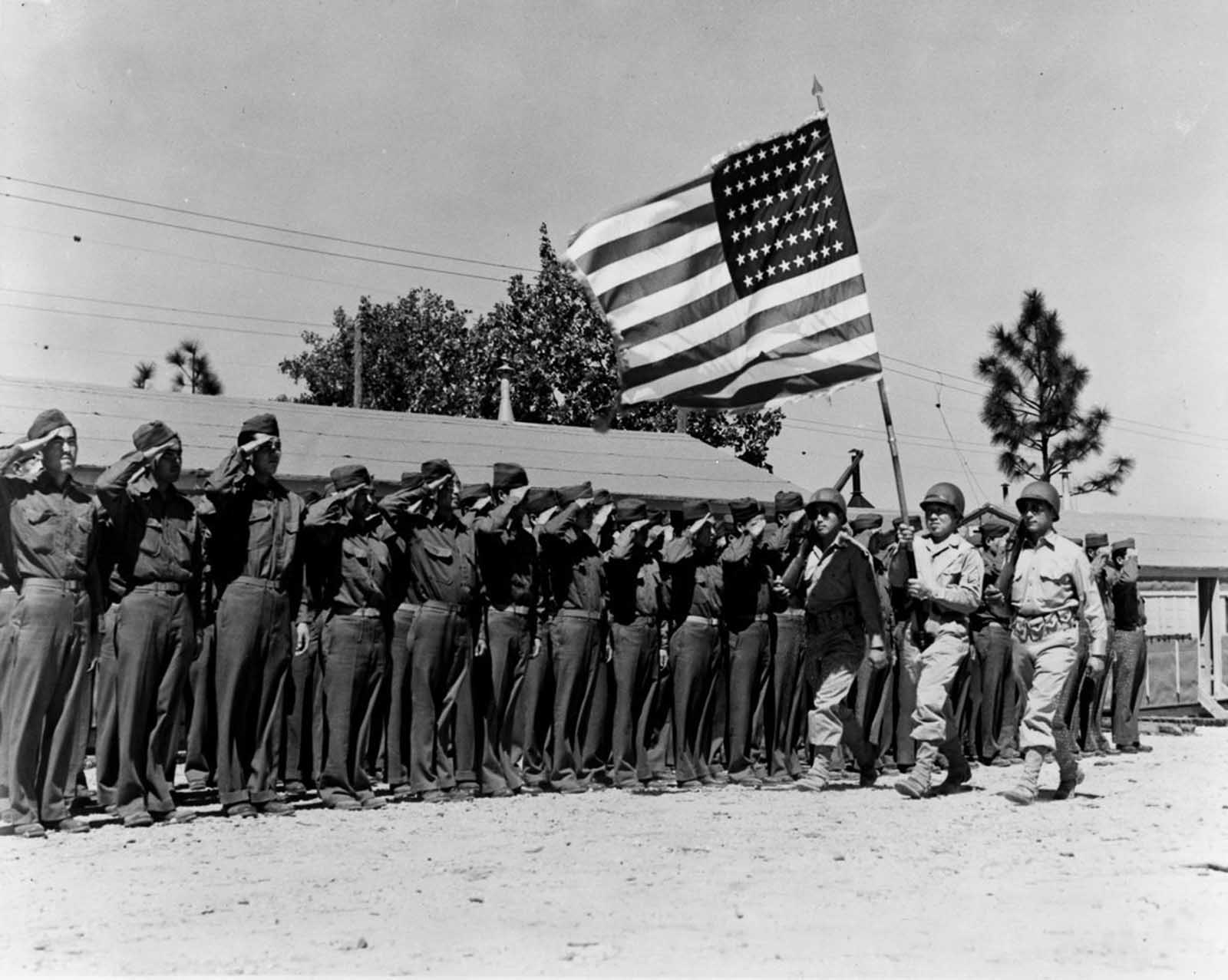 Soldiers of the 442nd salute the flag at Camp Shelby, Mississippi. June, 1943.