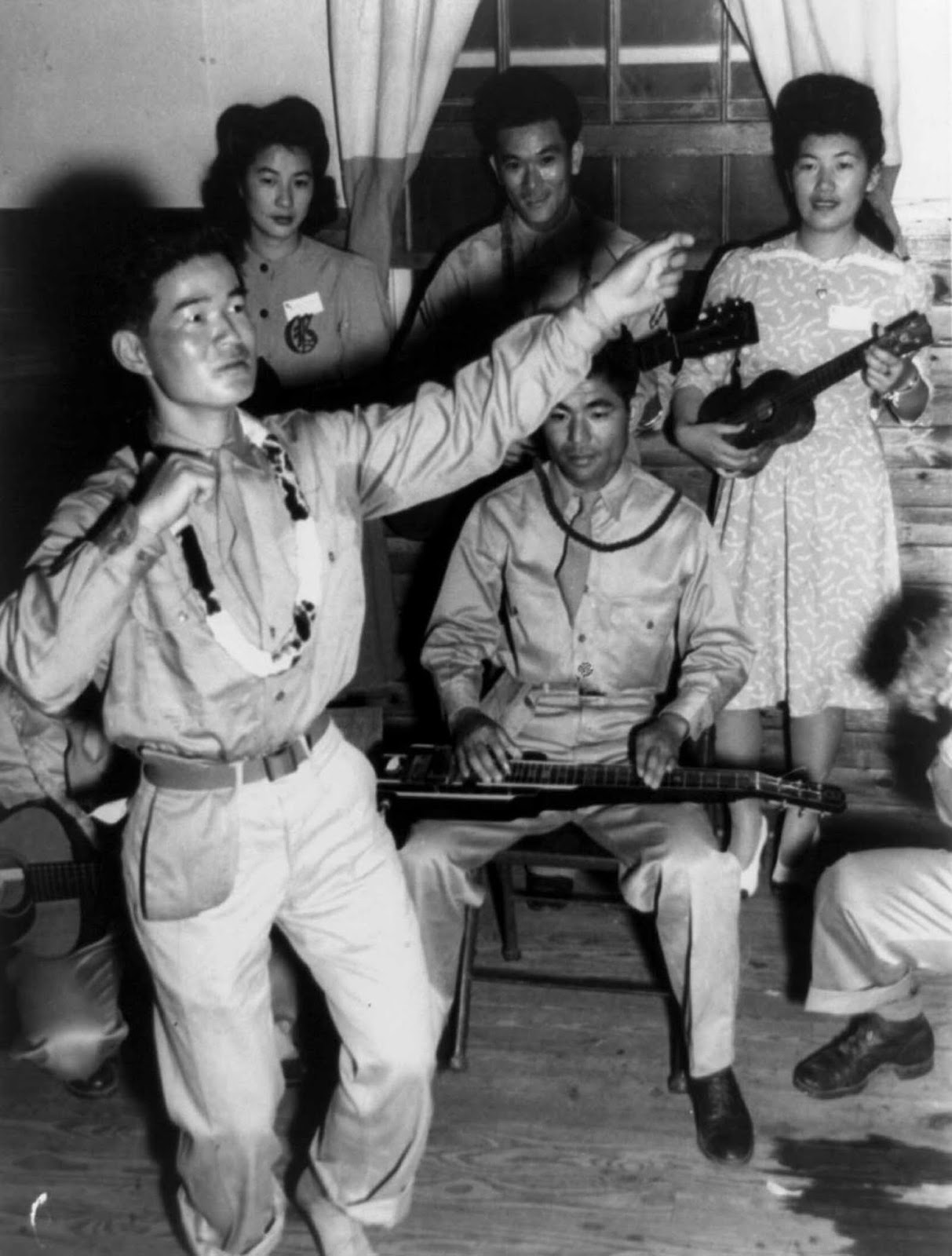 Private Harry Hamada does a hula dance with musical accompaniment. June, 1943.