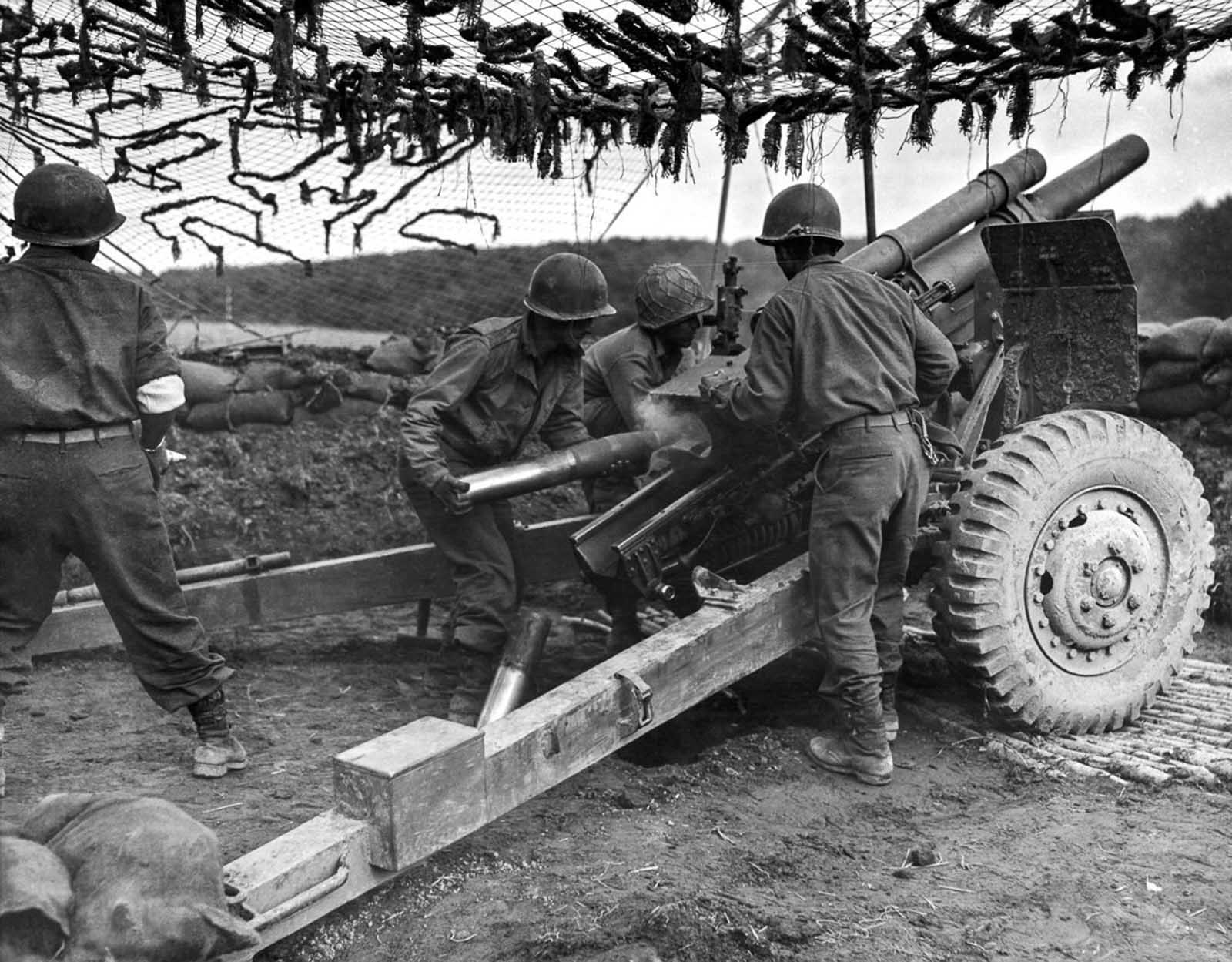 Soldiers fire 105mm shells at German positions to support an infantry attack in France. Oct. 18, 1944.