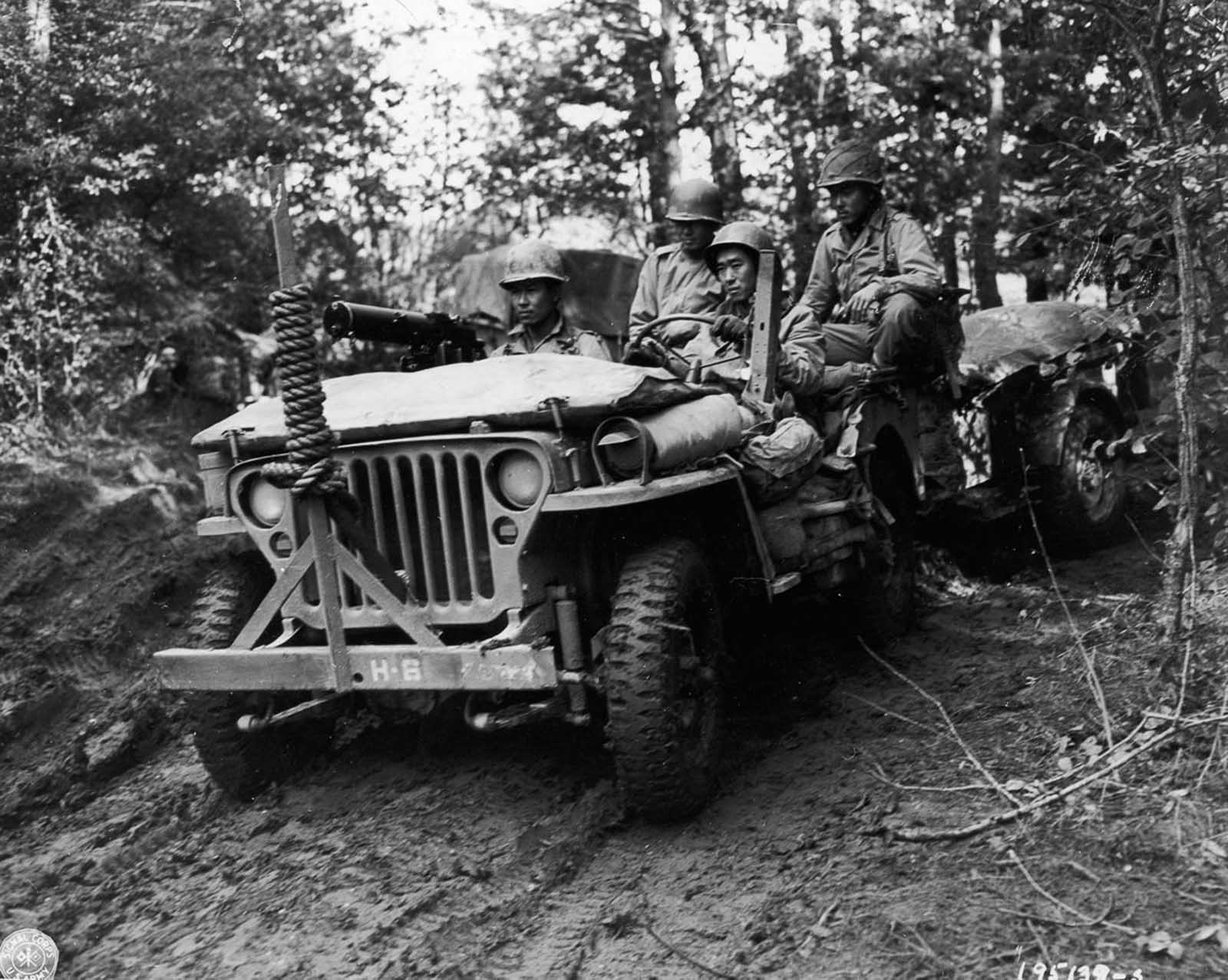 Soldier drive a Jeep towing a supply trailer in rural France. October 1944.