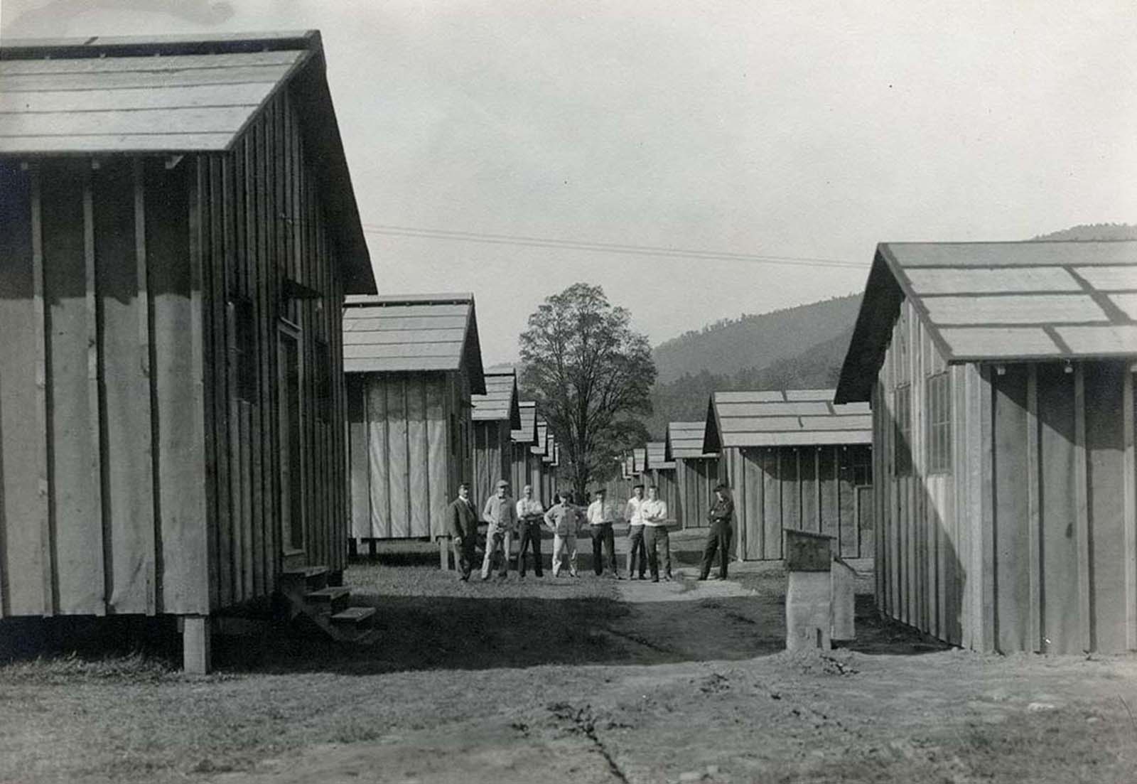 Internees pose among the barracks they helped to construct.