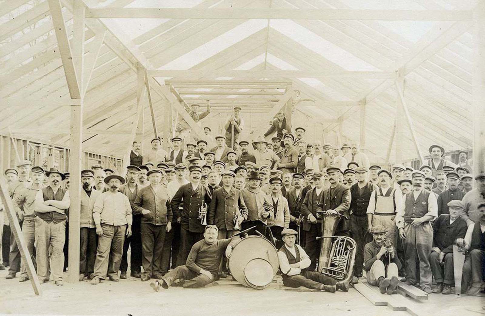 Internees and members of the German Imperial Band pose in a partially-constructed building.