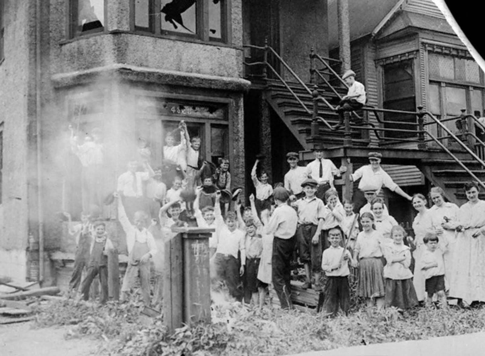 Kids cheering in front of a burning house.