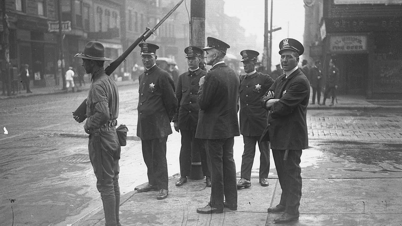 Five policemen and one soldier with rifle.
