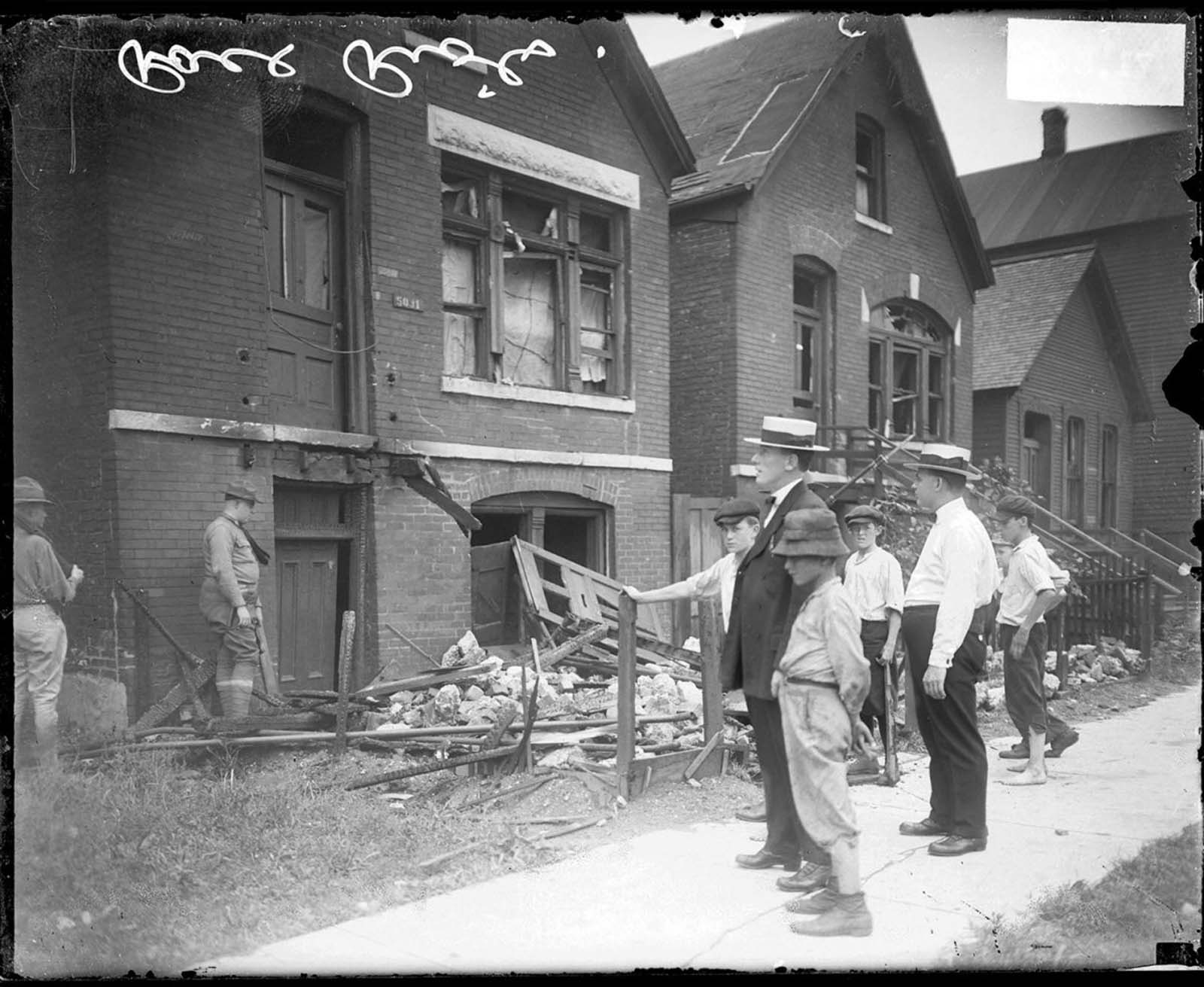 A group of white men and boys examine the destroyed homes of black Chicago residents after the city’s 1919 riot.