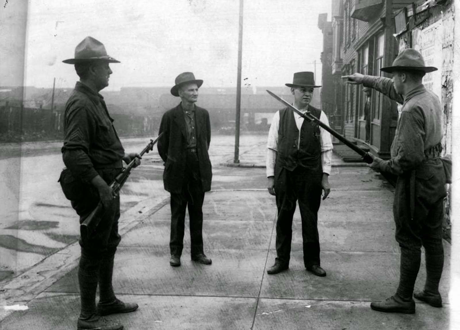 A soldier tells a man to back up during the race riots in Chicago in 1919. The soldiers were in place to keep white people in their own districts.