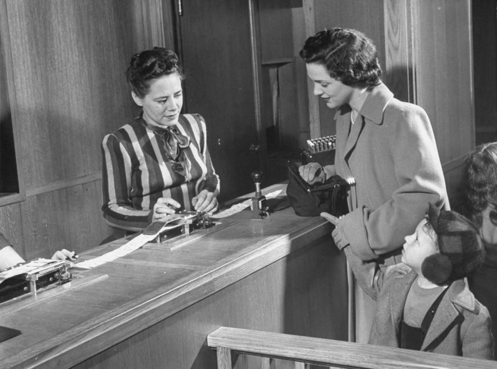 The shopper gives a punched-out card to the cashier, who totals the prices and triggers machinery behind the scenes.