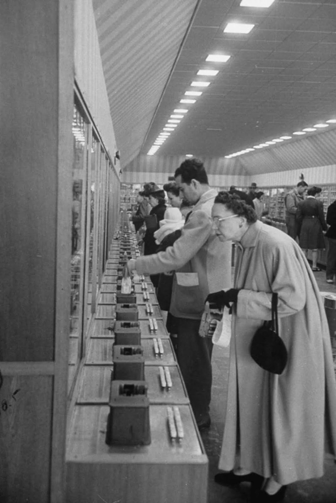 A shopper, key card in hand, searches for her items.