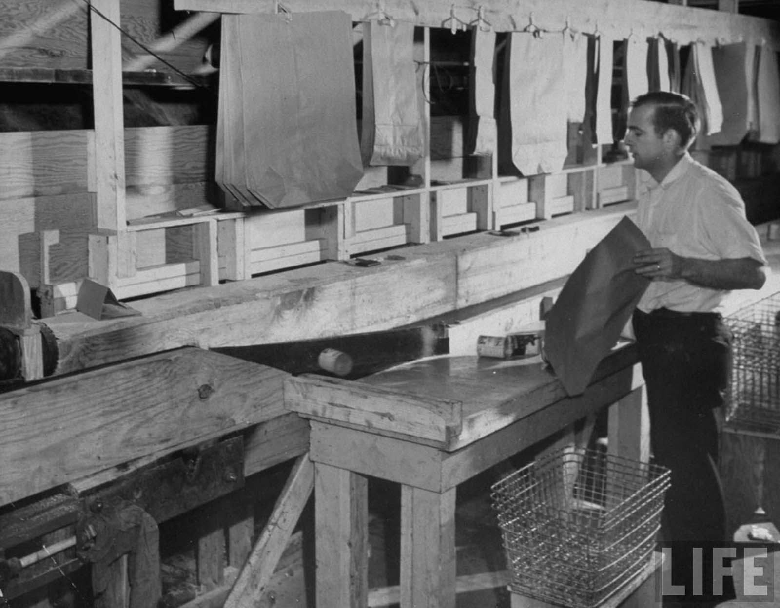 Keedoozle automatic grocery store’s employee bagging a customers order and placing it on a conveyor belt.