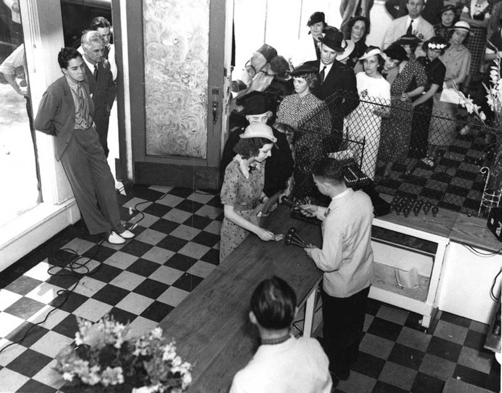 Saunders, in doorway on the left, watches as employees hand out keys to shoppers.