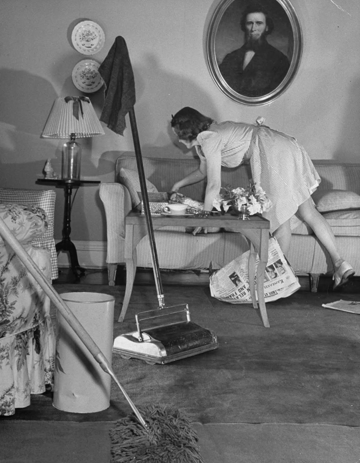 Jane busy straightening up before launching into some heavy cleaning with dust mop and carpet sweeper.