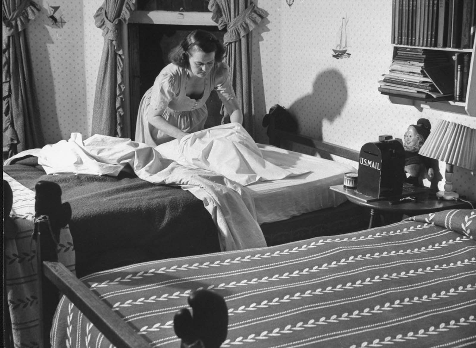 Jane making one of the four beds she does daily, after doing breakfast dishes and getting the kids to school.