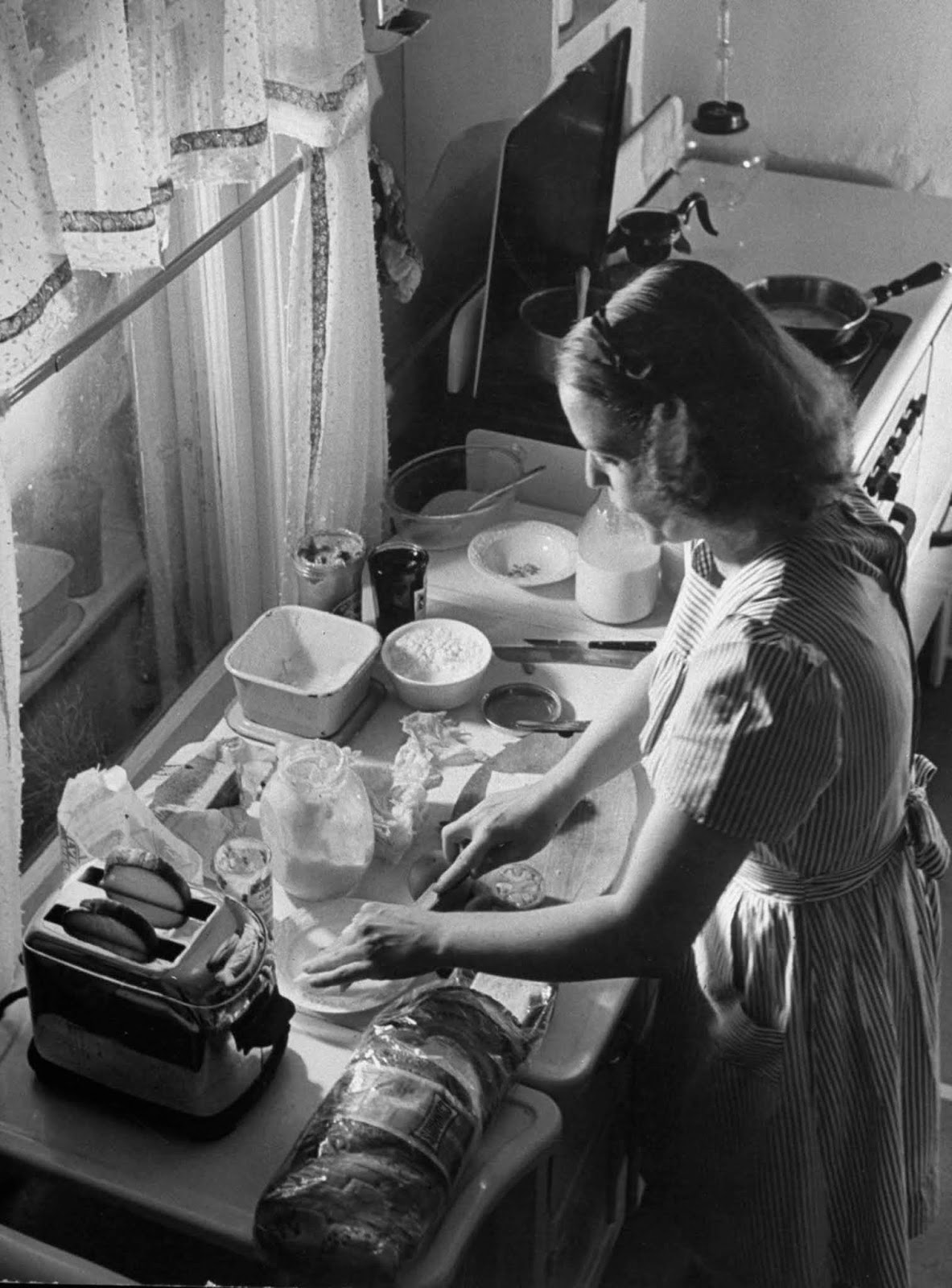 Jane using pop-up toaster, as she makes sandwiches for her three children.
