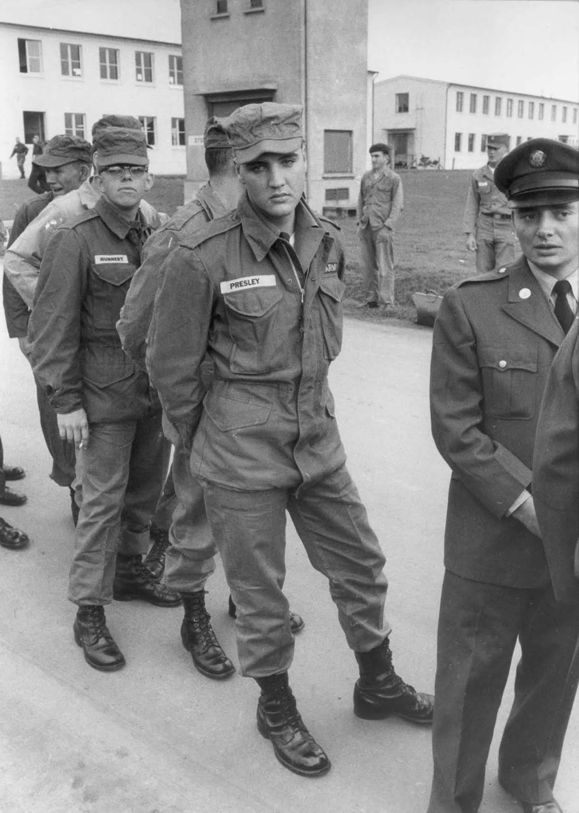 Presley stands in line with other enlisted men and officers on a military base, Germany.