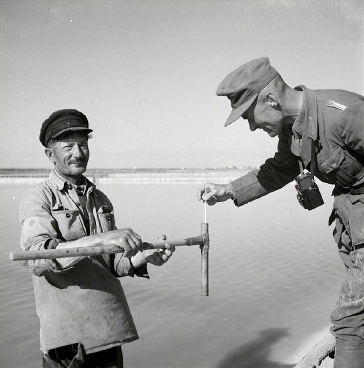 A Wehrmacht soldier with a local fisherman.