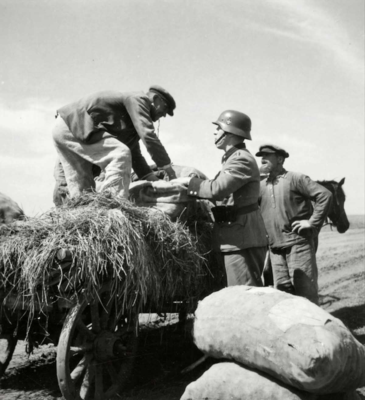 A German soldier bargaining with a farmer (or maybe confiscating it).