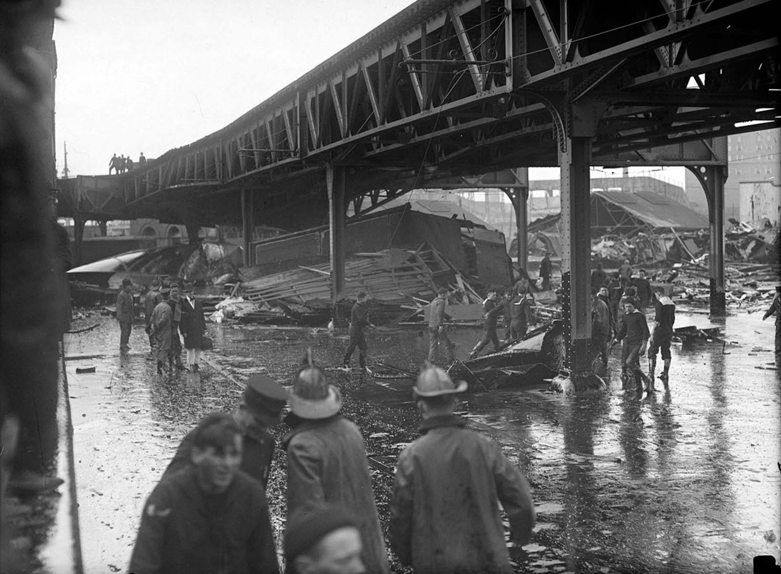 Firefighters and others stand in a pool of molasses after the explosion of a molasses storage tank owned by the United States Industrial Alcohol Company in Boston on January 15, 1919. About 2.3 million gallons of molasses flooded the area, killing 21 people, injuring 150, trapping a dozen horses, and destroying buildings, homes and part of the elevated train.