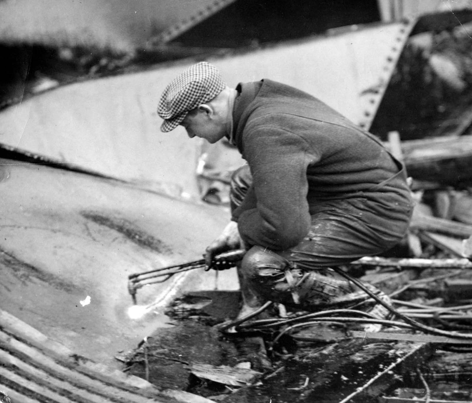 Welders carefully began cutting up the molasses tank with torches in the search for bodies on Jan. 20, 1919, five days after the Great Molasses Flood in Boston’s North End. Even though firemen constantly sprayed water on the twisted wreckage, it wasn’t until the city ordered powerful streams from its fireboat that the molasses began to dissipate. The salt water of the harbor “cut” the molasses and eventually the welders could see the structure of the original tank.