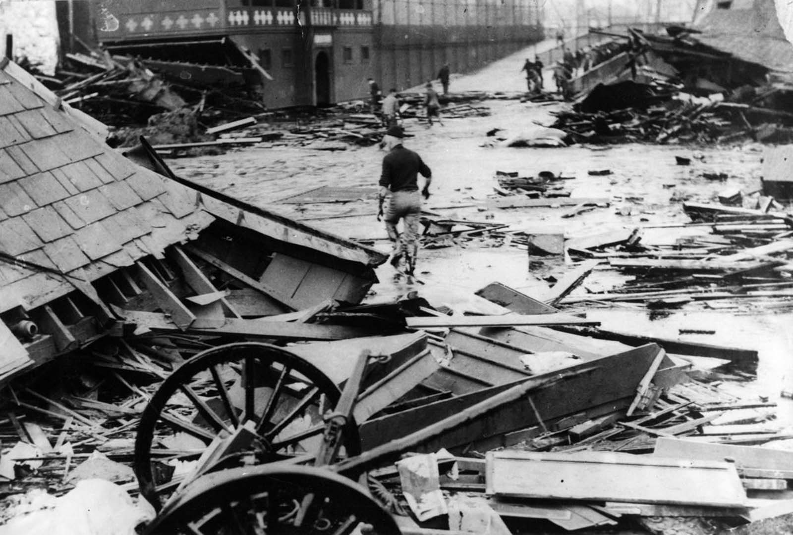 A man walked through the debris a day after the molasses tank suddenly ruptured, unleashing a wave that reached a depth of 15 feet and in places and was 100 yards wide over a two block area.