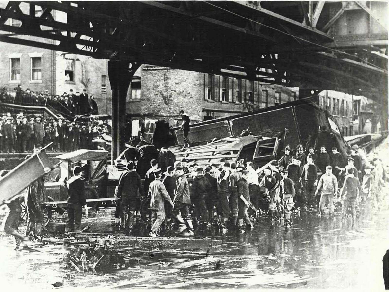 Rescuers tried desperately to save the occupants of the Clougherty house, which was torn from its foundation and smashed against the elevated train trestle by the molasses wave.