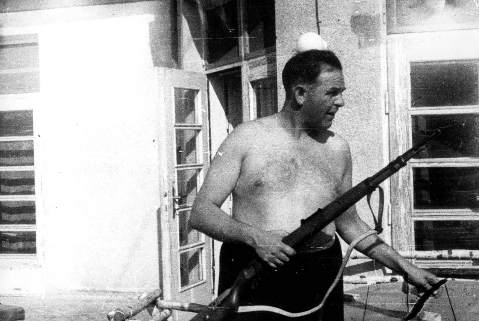 Commandant Amon Leopold Goeth holding a military rifle.