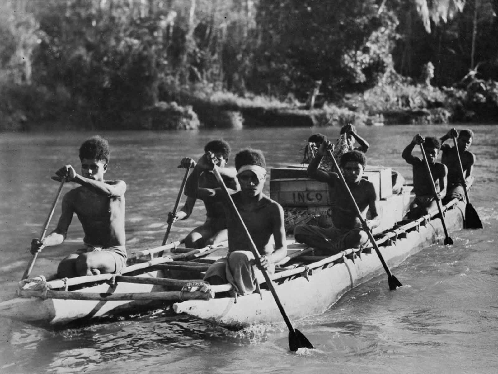 Supply carriers paddle a boat bearing supplies.