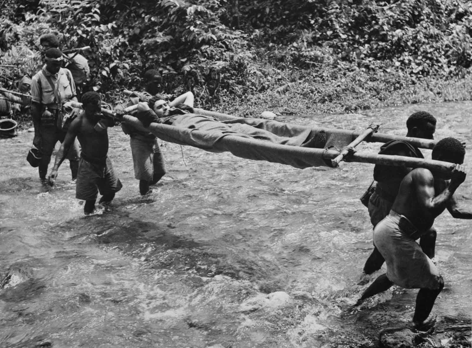 Stretcher bearers evacuate a wounded Australian soldier following a battle at Kokoda.