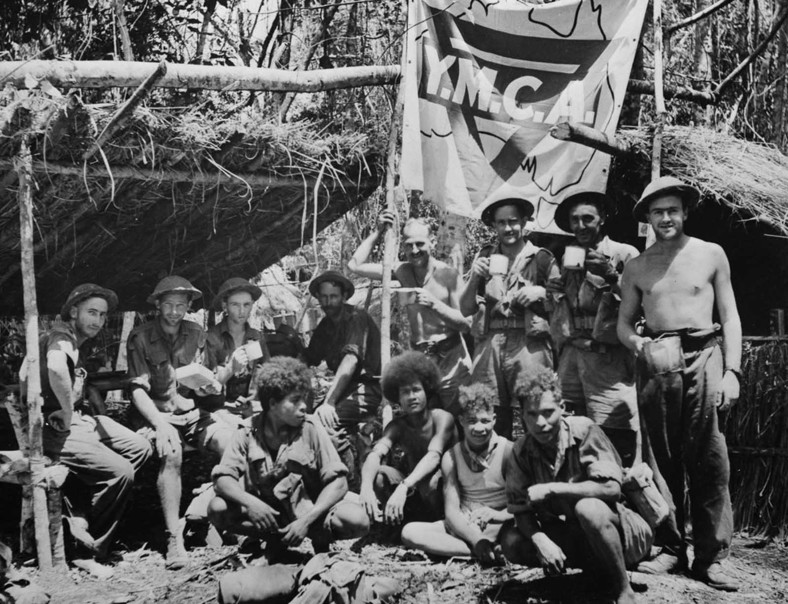 Natives and Allied troops rest during the New Guinea offensive.