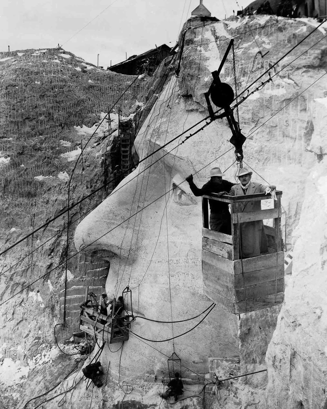 Gutzon Borglum and his son Lincoln supervise the progress on Thomas Jefferson's head. 1935.