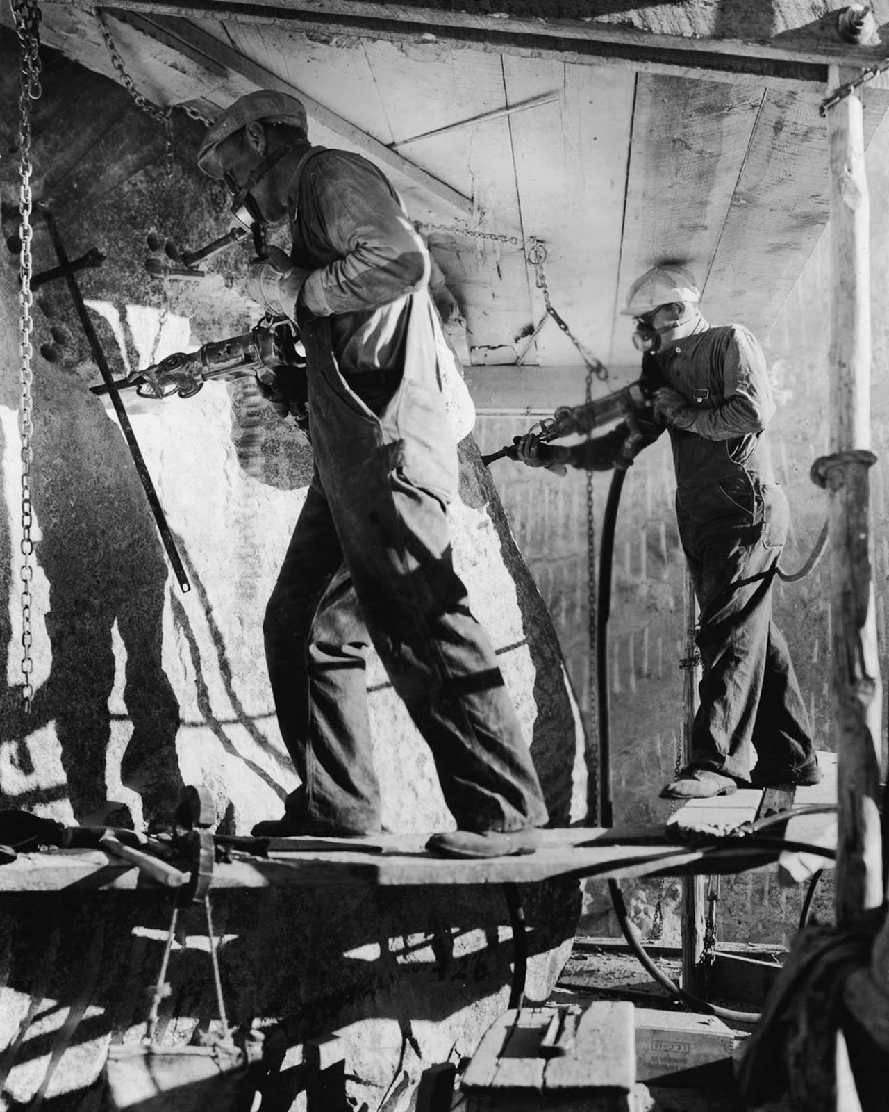 Stone workers carve the eyes of Theodore Roosevelt with air hammers. 1940.