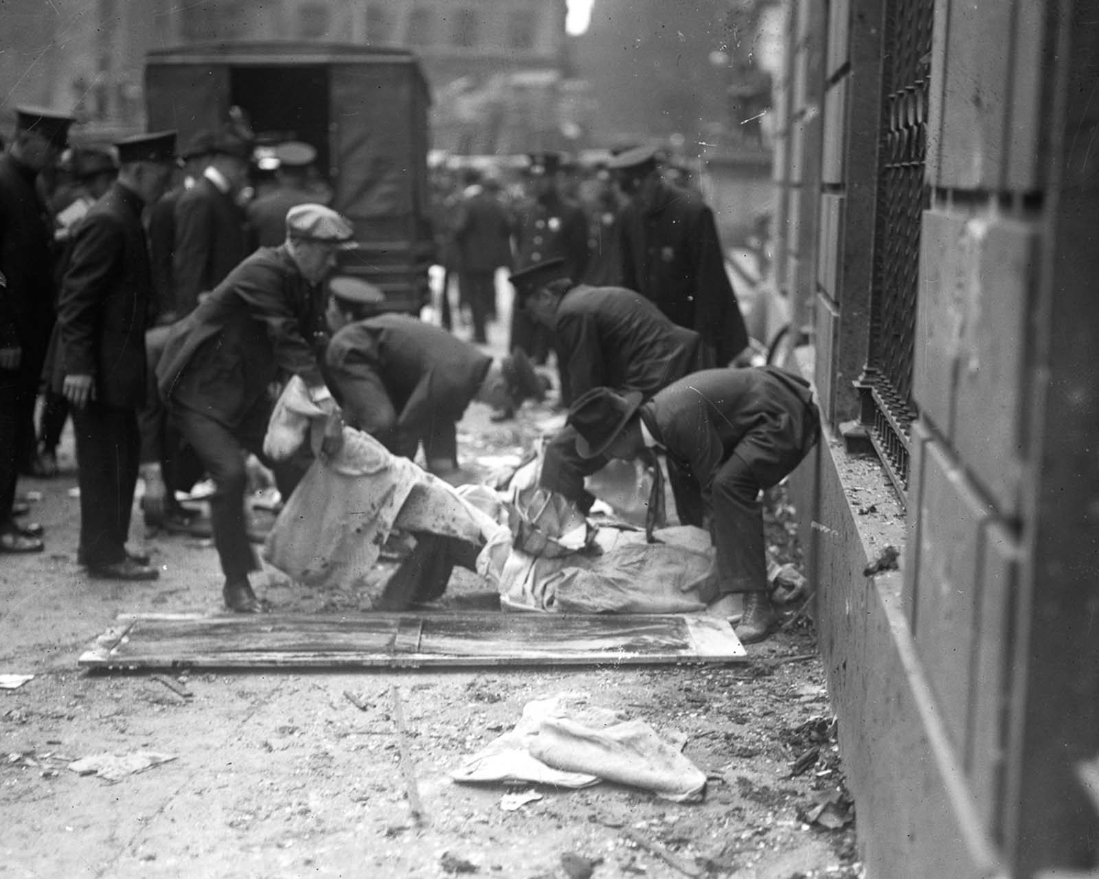 Police and volunteers load the bodies of victims onto stretchers.