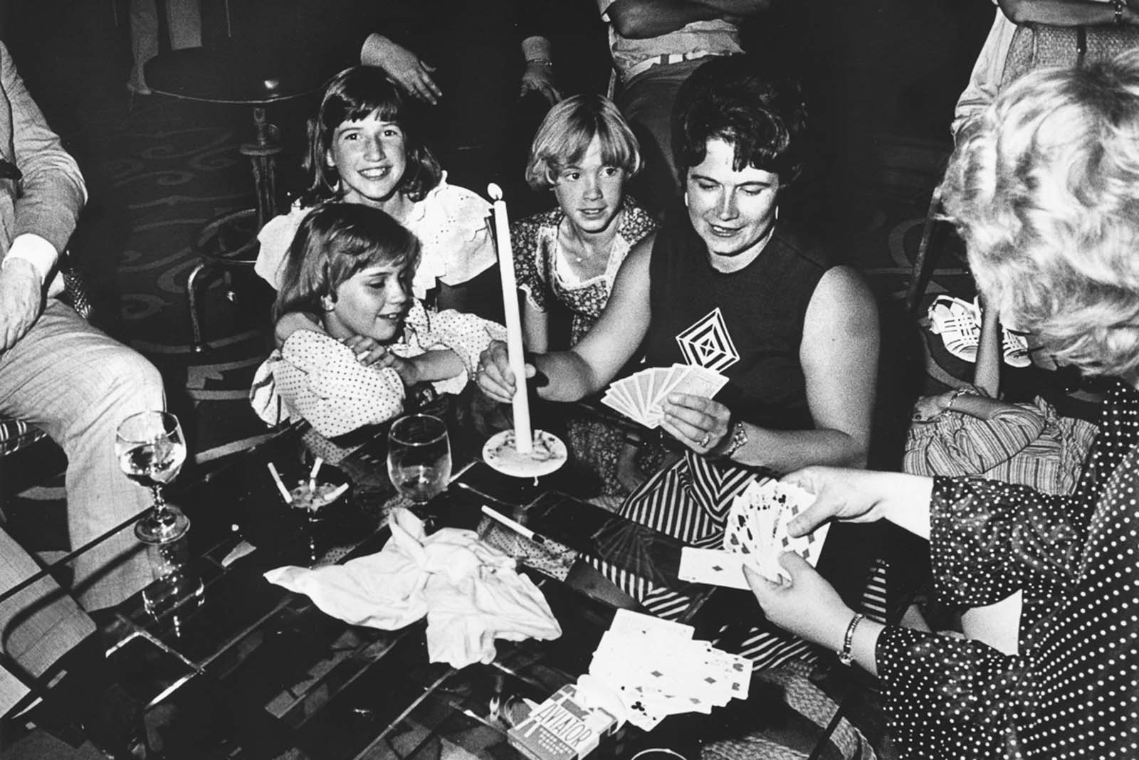 People playing a game of cards by candle light during the New York blackout.