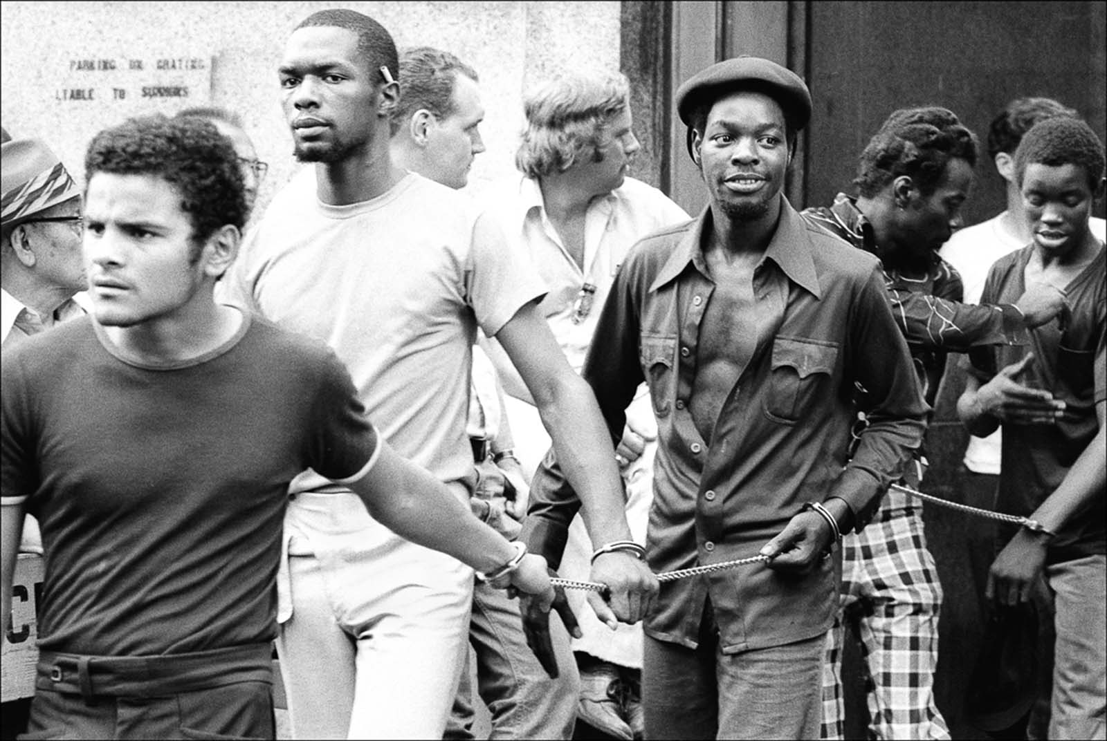 Suspected looters are chained together after being arrested.