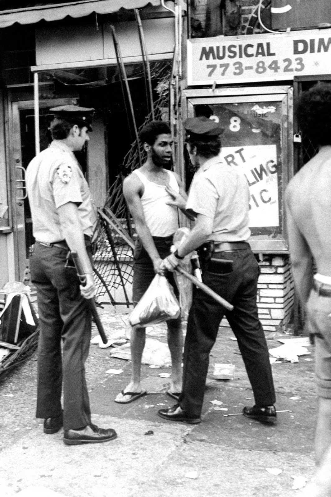 A police officer arrests a suspected looter.